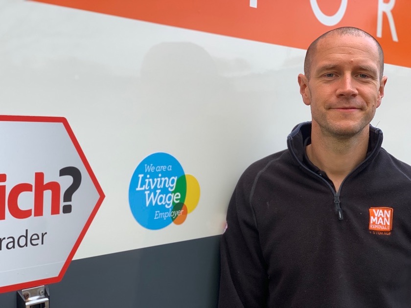 A man in front of a living wage employer Exeter removal van
